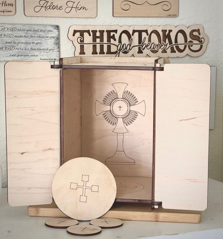 Wooden Tabernacle with open doors . Wooden paten and 3 wooden hosts displayed